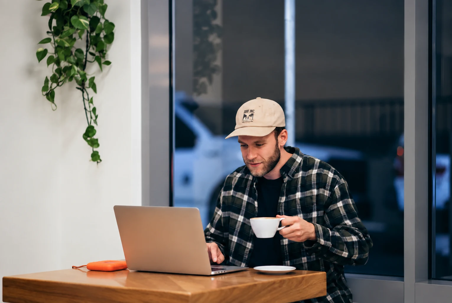 Man working on a laptop with a coffee in a cafe